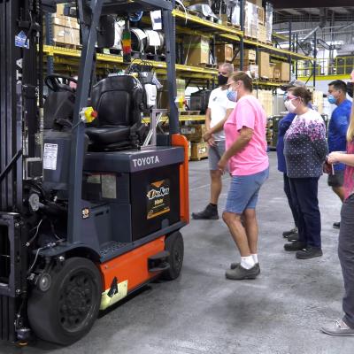 Employees observe self-driving forklift