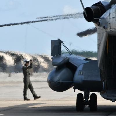Cpl. Devon Schoff, a CH-53 crew chief at Fleet Readiness Center East (FRCE), signals to the pilot as the aircrew prepares to return a recently overhauled CH-53 helicopter to the fleet. 