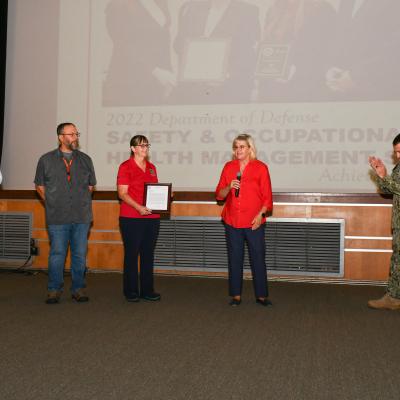 Fleet Readiness Center East (FRCE) Commanding Officer Capt. James M. Belmont and FRCE Compliance and Quality Department Head Amy Morgan congratulate members of the depot’s safety team for their recognition by the North Carolina Department of Labor Safety Awards Program. 