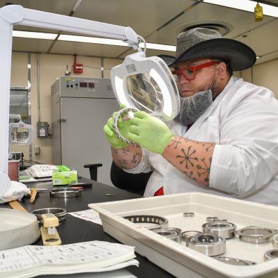 Chad Bogdahn, a bearing reconditioner at Fleet Readiness Center East (FRCE), inspects a bearing inside the depot’s bearing shop. FRCE’s Bearing Shop refurbishes hundreds of bearings each week, turning out several thousand each month. The shop works with nearly 5,000 different part numbers ranging from bearings used on CH-53 helicopters to those used in military hovercraft variants. 