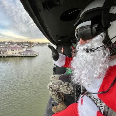 Santa Claus waves to good girls and boys on the pier from an airborne helicopter over the Patuxent River.