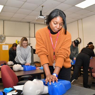 China Taylor, a training administrator at Fleet Readiness Center East (FRCE), practices CPR techniques on a training dummy during a class focused on first aid, CPR and use of an automated external defibrillator. While the training is a mandatory requirement for some FRCE employees, the depot’s goal is to enhance readiness by training personnel throughout the work force. 