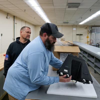 Eric Gares, front, oxygen equipment repair mechanic, and quality assurance inspector Josh Unruh put the final touches on the 100th F-35 Lightning II parachute repacked at Fleet Readiness Center East (FRCE). FRCE achieved this milestone less than one year after inducting their first F-35 parachute. Since 2018, the depot had declared capability on 32 components, including the parachutes for the fifth-generation fighter. 