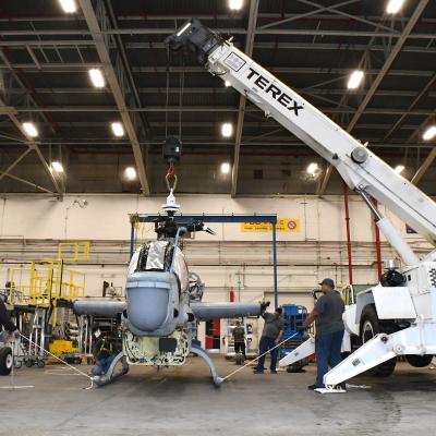 Workers prepare AH-1Z airframe for lift by crane