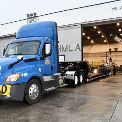 Truck with double-drop trailer backs into aircraft hangar