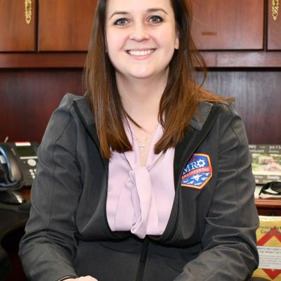 FRC East mentor poses for portrait behind desk