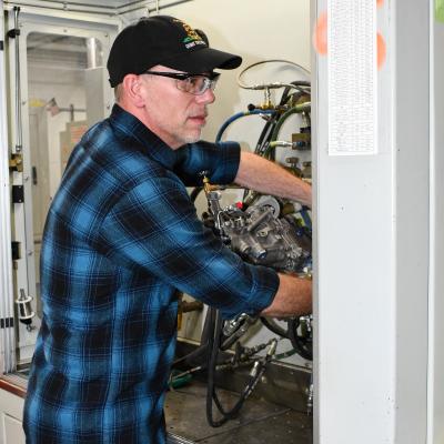 Aircraft maintainer connects fuel control unit to test stand for evaluation