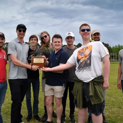 Fleet Readiness Center East (FRCE) engineers Davis Harrison, far left, and Josh Rusmisel, far right, pose with students and faculty from Croatan High School who took first place in the 2023 Ultimate Unmanned Aerial Vehicle Competition, held April 22 in Newport. Students representing eastern North Carolina high schools designed unmanned aerial vehicles for the competition, which evaluated the speed and maneuverability of their creations. 