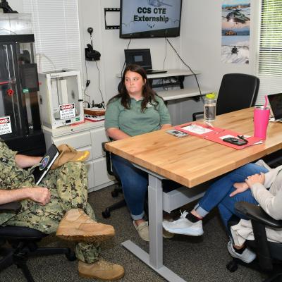 Fleet Readiness Center East (FRCE) Capt. James M. Belmont, left, talks with local educators as part of an externship program FRCE hosted aimed at showcasing career opportunities to area students. The program is part of FRCE’s outreach efforts which focus on engaging, inspiring, and educating students from eastern North Carolina while highlighting the wide range of career opportunities available at the depot. 