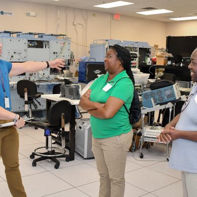 Fleet Readiness Center East (FRCE) Jesse Gora, an engineer at FRCE, left, guides a tour of local educators during a four day externship program focused on preparing students for careers in industry. The program is part of FRCE’s outreach efforts which focus on engaging, inspiring, and educating students from eastern North Carolina while highlighting the wide range of career opportunities available at the depot.