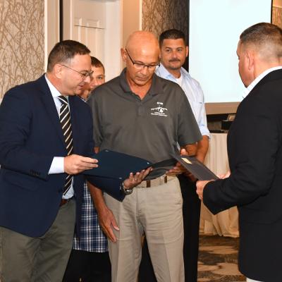 Italian Navy AV-8B Deputy Program Manager Cdr. Sergio D’Agostini, left, presents Fleet Readiness Center East (FRCE) aircraft electrician Eric Ellenberger with a letter of appreciation citing the successful completion of Harrier upgrades performed at Naval Air Station Grottaglie in Italy. Ellenberger was one of six FRCE employees recognized for their support of the Italian AV-8B Harrier fleet. 