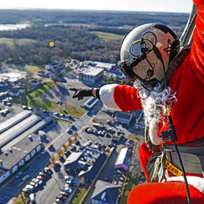 Santa waves to residents below from the skies of Southern Maryland aboard an in-flight MH-60S Seahawk helicopter.