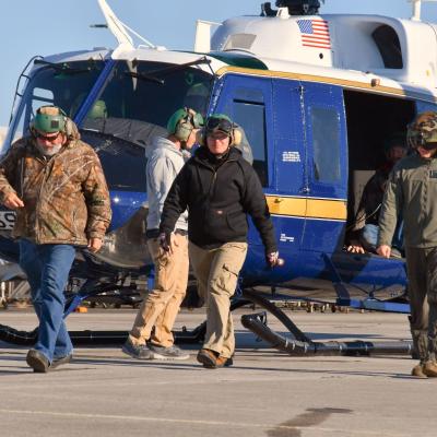 Marine and civilian ground walk in front of Air Force UH-1N helicopter following functional check flight 