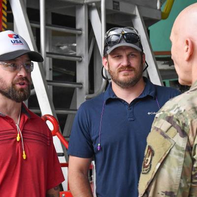 Air Force major general talks to two civilian aircraft maintainers