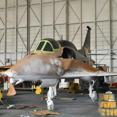 Aircraft with brown paper taped to it and white paint on bottom half