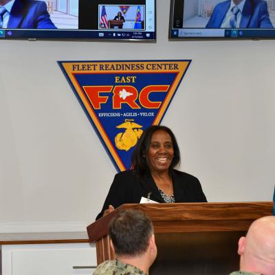 woman smiling while standing behind podium 
