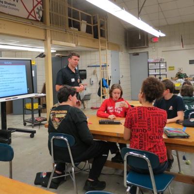 Man gives students a presentation in a classroom setting