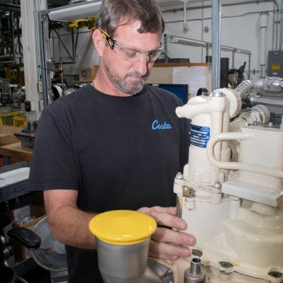 Ryan McNeil, a pneudralics systems mechanic at Fleet Readiness Center East (FRCE) works on an auxiliary power unit used in the F/A-18E/F Super Hornet. FRCE recently achieved a significant production milestone by eliminating high-priority backorders for auxiliary power units used in the Super Hornet, bolstering the platform’s mission readiness. 