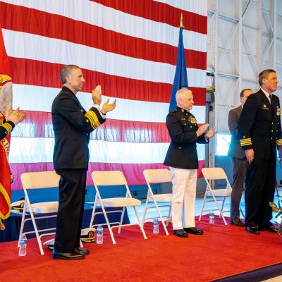 Sailors standing and clapping on a stage
