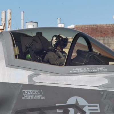 Pilot sits in F-35B Lightning II cockpit with canopy down.