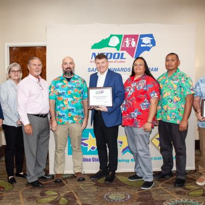 Group of people posing for photo, holding award certificates