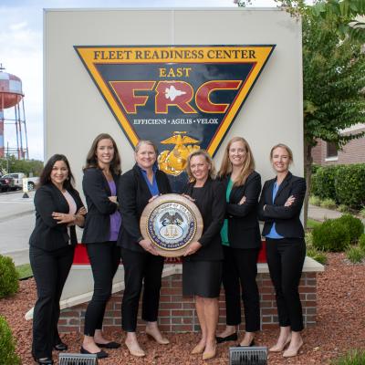 Group of professionally dressed staff pose for group photo