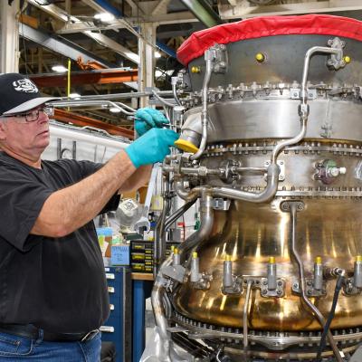 Man performs maintenance on aircraft engine