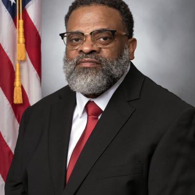 Studio portrait of man in suit in front of American flag