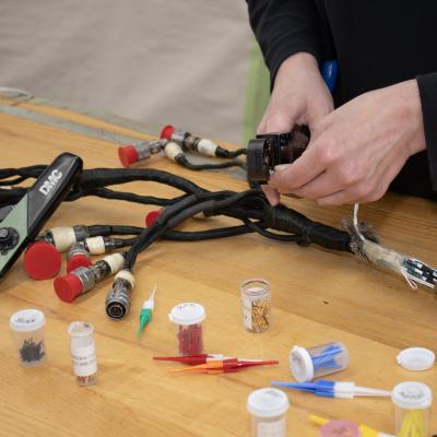 Person's hands working on a wiring harness