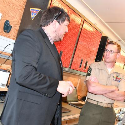 Engineer and Marine hold conversation in mobile fabrication lab trailer