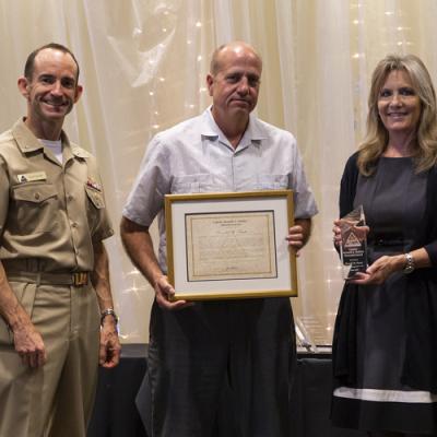 Ronald Pruitt accepts the Capt. Kenneth A. Walden Memorial Award from Rear Adm. Scott Dillon, NAWCWD commander, and Joan Johnson, NAWCWD executive director, during the 2019 Honorary Awards Ceremony at China Lake on June 25. (U.S. Navy photo by Ryan Smith)