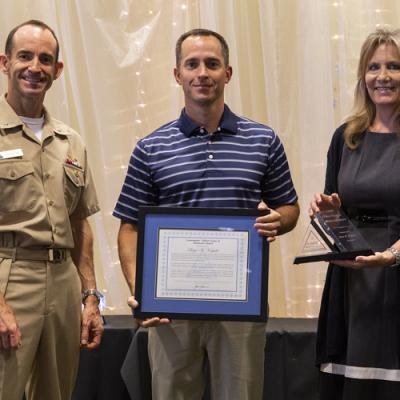 Bryce Vorpahl accepts the Cmdr. Clifton Evans Jr. Memorial Award from Rear Adm. Scott Dillon, NAWCWD commander, and Joan Johnson, NAWCWD executive director, during the 2019 Honorary Awards Ceremony at China Lake on June 25. (U.S. Navy photo by Ryan Smith)