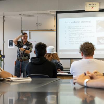 Naval Air Warfare Center Weapons Division Chief Engineer for the Ordnance Test and Evaluation Division David Hall teaches students at Burroughs High School the principles of rocketry in preparation for the annual rocket launch May 29 in Ridgecrest, Calif. (U.S. Navy photo by Ryan Smith)