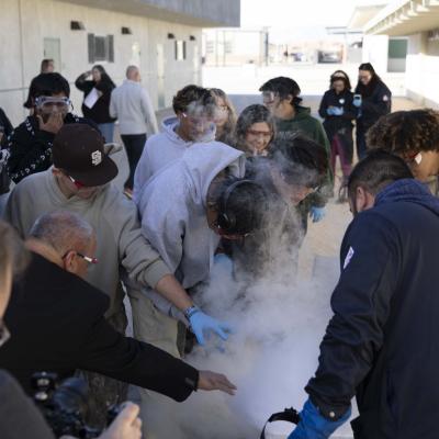 Naval Air Warfare Center Weapons Division Executive Director Dan Carreño (second from left) joins a group of students during a liquid nitrogen experiment performed by NAWCWD Chemist Dr. Patrick Fedick (right) during a Burroughs High School STEM event last fall in Ridgecrest, Calif.  (U.S. Navy photo by Ryan Smith)