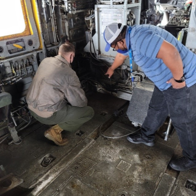 A civilian corrosion expert shows a naval aviator corrosion up close aboard the CH-53K King Stallion.