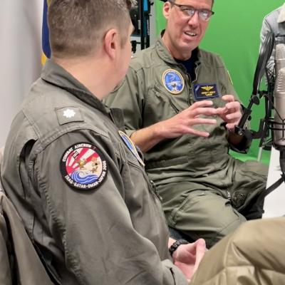 Pilot in flight suit sitting at a table for an interview