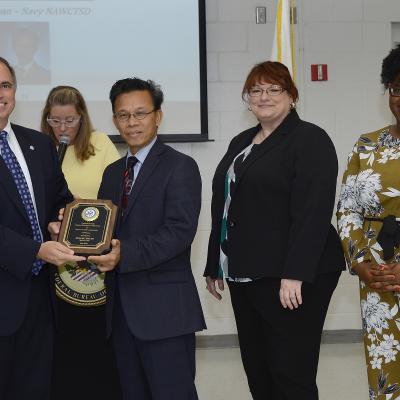 John J. Daly, President of the Central Florida Federal Executive Association presents Hoang "HD" Doan (NAWCTSD 4.6.8.5) with the association's Federal Employee of the Year Award for Service to the Community. The awards ceremony held during Public Service Recognition Week honored the contributions of federal employees throughout Central Florida.  