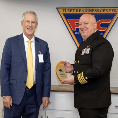Sailor poses for award photo with man in blue suit