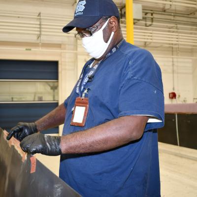 Man repairs H-53 helicopter main rotor blade