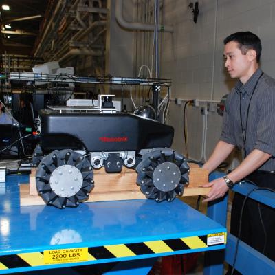 Dr. James Hing moves a robot inside the Robotics and Intelligent Systems lab at Lakehurst