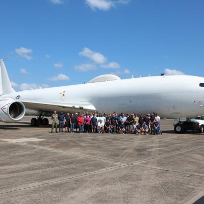 Team members pose with E-6B Mercury on flight line. 