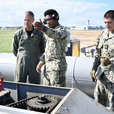 Vice Adm. Carl Chebi, left; ABH2 Rhajhae Ebanks, center; ABH2 Billy VanDamme, right;  views the E-28 Arresting System at NAS Patuxent River Airfield Services Division, Oct. 4.