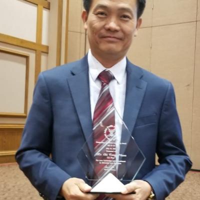 Pham holds award.