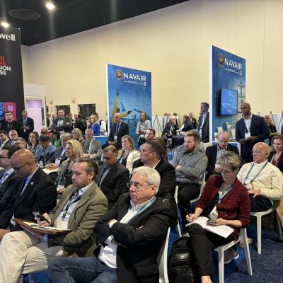 Audience members listen to a presentation given by NAVAIR leadership