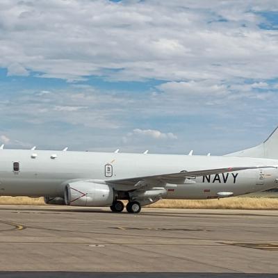 Plane on tarmac with blue skies and clouds