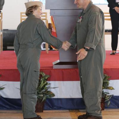 Capt. Elizabeth Somerville shakes hands with Col. Richard Marigliano in front of the podium during a change of command ceremony.