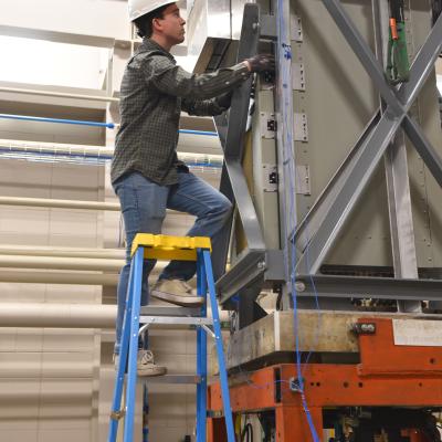 ETL teammate checks a piece of equipment during testing