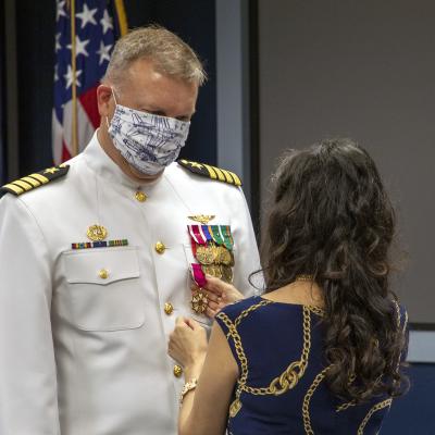 Capt. A.J. McFarland watches as his wife Clarisa pins him with the Legion of Merit during a change of command ceremony June 19 in Point Mugu, California. (U.S. Navy photo by Brian Wulfekotte)