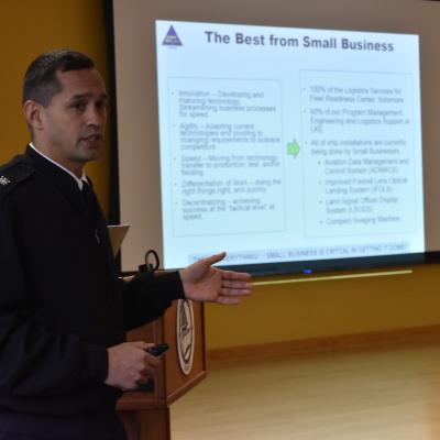 Officer-In-Charge Cmdr. Walter A. Reynolds briefs "The Best from Small Business" slide