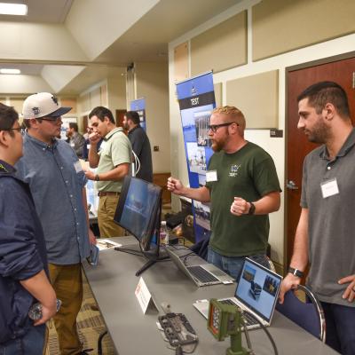 Participants visit one of the tables at Naval Air Warfare Center Aircraft Division Lakehurst's Open House